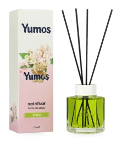 Yumoş Acacia 130 ml, odorizant de cameră cu flacon verde-gălbui, patru bețișoare negre și cutie alb-roz decorată cu flori.