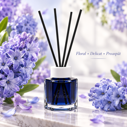 Odorizant Yumoş Hyacinth 120 ml cu flacon albastru și patru bețișoare negre, în decor cu flori mov de zambilă și descrierea aromei florale.